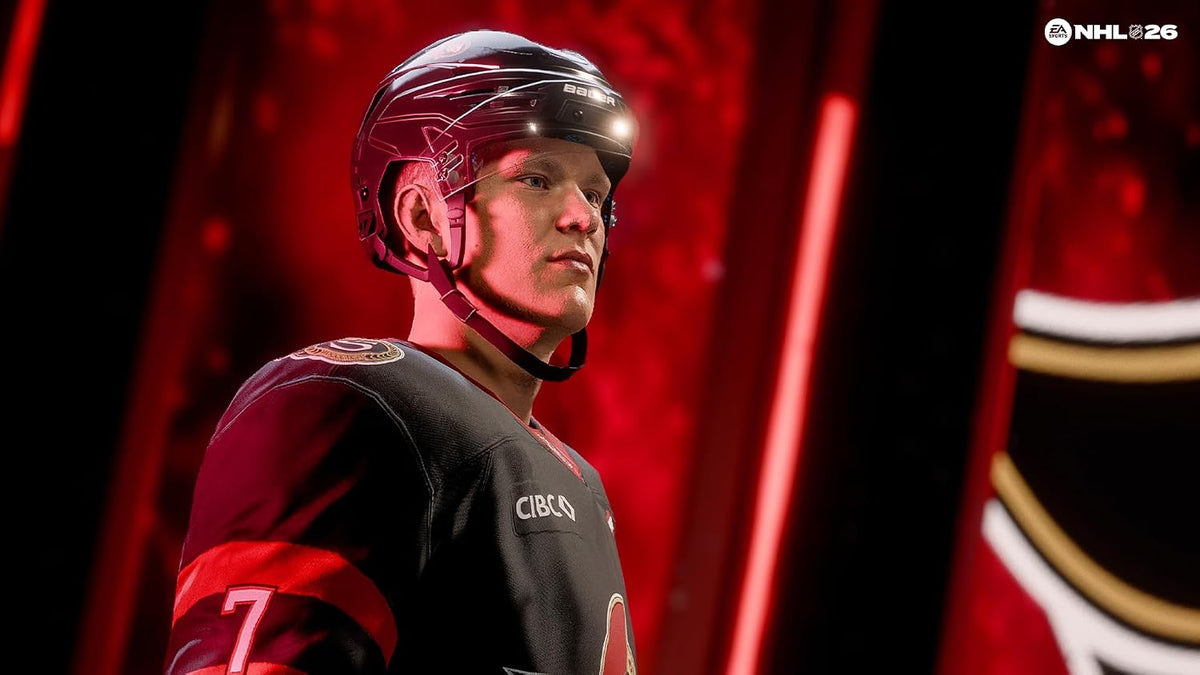 Hockey player in a black and red uniform with helmet, standing against a red curtain background.