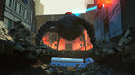 A dramatic sci-fi scene showing a large dark mechanical arch or gate structure in a ruined city street, with a blue semi-truck underneath and bright orange-red light effects in the background.