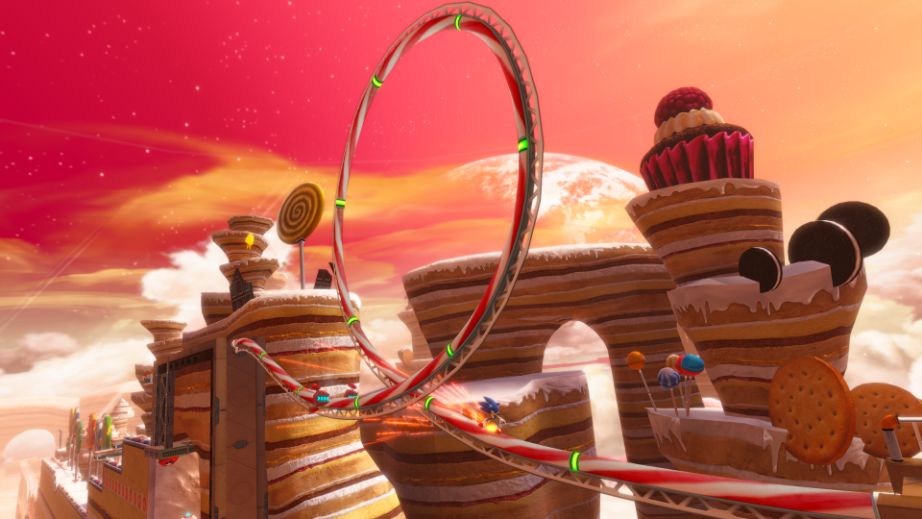 Fantasy landscape with cupcake-like structures and a ring in the foreground against a sunset sky.