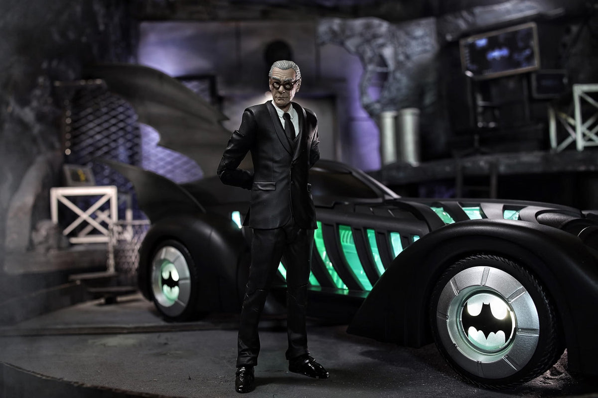 Alfred Pennyworth action figure standing beside the McFarlane Batman Forever Batmobile