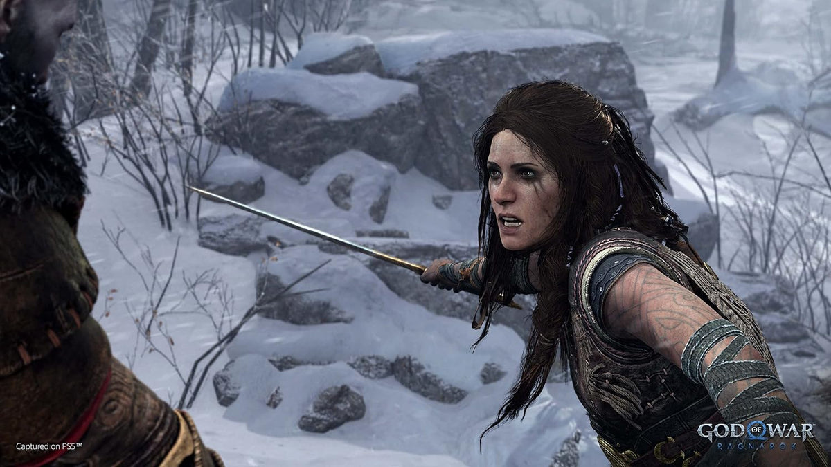 God of War Ragnarök PlayStation 5 screenshot featuring Freya in a snowy landscape, showing detailed character design and cinematic storytelling.