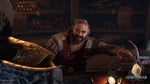 God of War Ragnarök PS5 cinematic screenshot showing a bearded Norse character speaking inside a warmly lit interior during a story sequence.