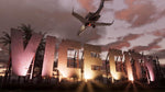 Airplane flying above an illuminated Vice city skyline at sunset