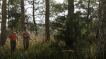 Two characters standing among tall trees and dense undergrowth in a woodland scene