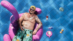 Man lounging on a pink inflatable flamingo pool float in a pool with drinks and a bottle cap. GTA 6 Vice city for PS5