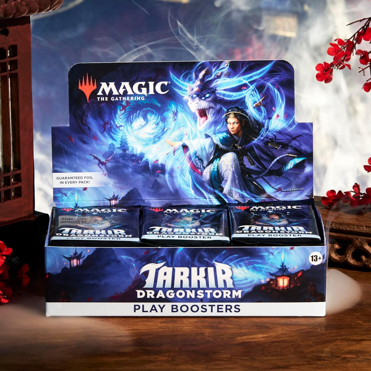 Magic The Gathering Tarkir Dragonstorm Play Booster Box promotional display featuring official blue dragon artwork and sealed MTG trading card booster packs.