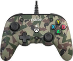 Nacon Pro Compact Wired Controller in Forest Camo for Xbox Series X|S, Xbox One and PC, front view showing green camouflage casing, offset analogue sticks and Xbox buttons.