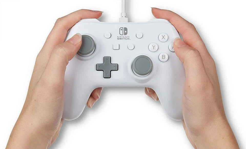 PowerA Officially Licensed White Wired Nintendo Switch Controller held in both hands, demonstrating its comfortable ergonomic grips, thumbstick placement and button layout.