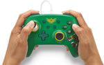 PowerA Hyrule Defender Nintendo Switch wired controller held in both hands, demonstrating its ergonomic green grips, analogue sticks and gaming button layout.