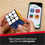 Hands holding a Rubik's Cube ConnectedX beside a smartphone displaying colourful game icons