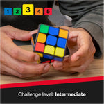 Close-up of hands holding a scrambled Rubik's Cube ConnectedX beneath numbered coloured icons